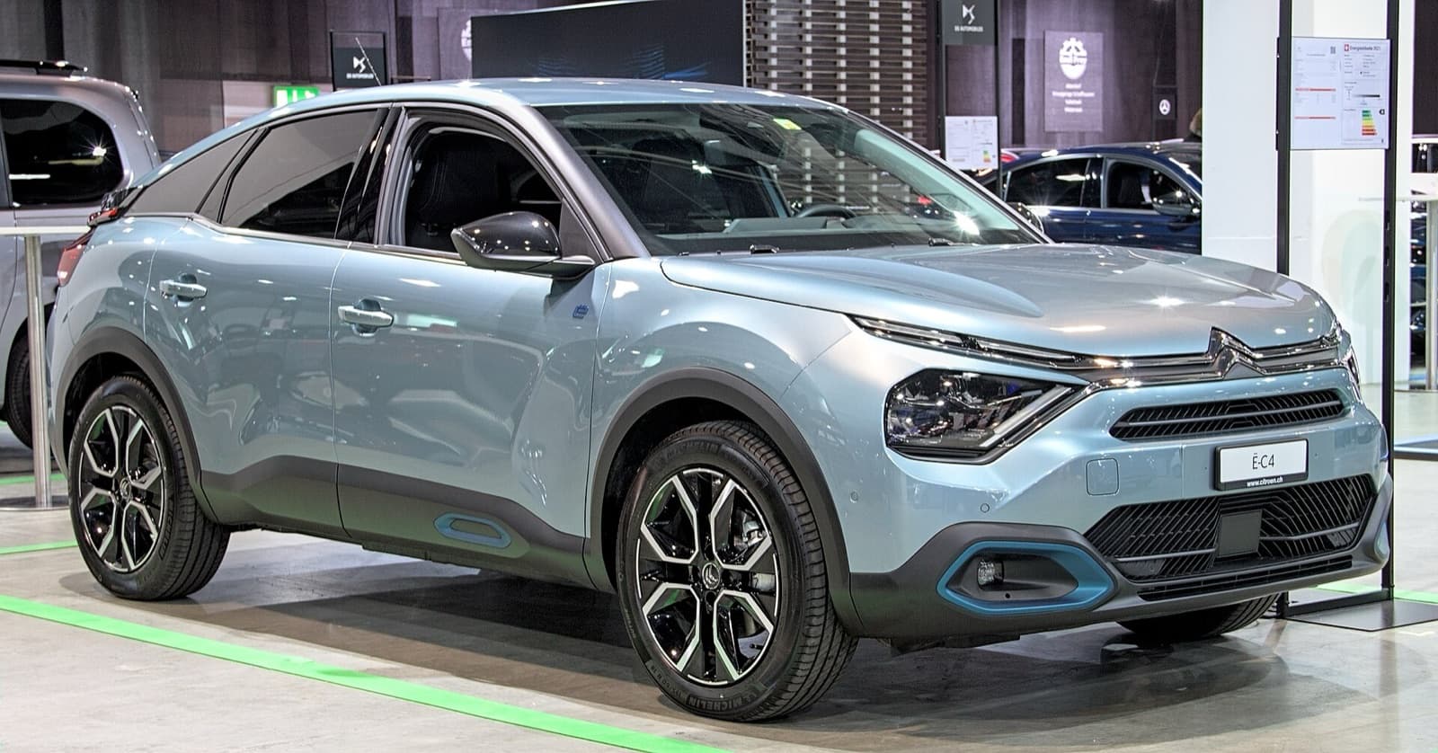 A light blue Citroën ë-C4 electric fastback-crossover on display at a motor show