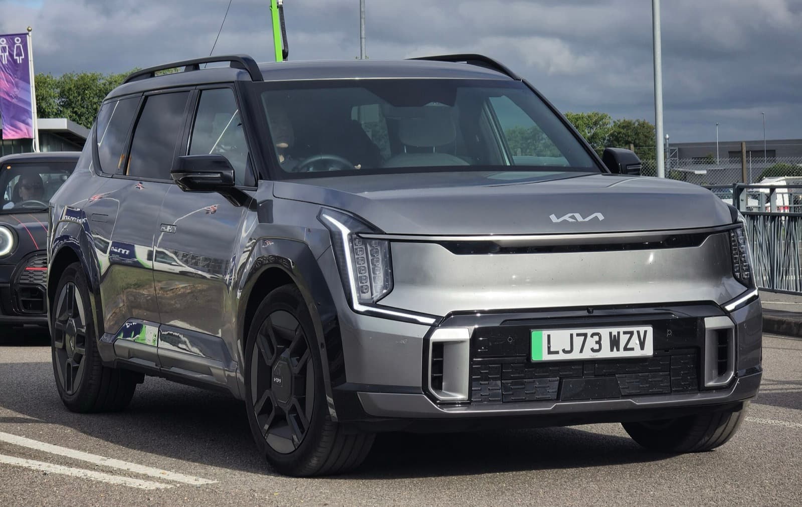 A grey Kia EV9 large three-row electric SUV in a car park