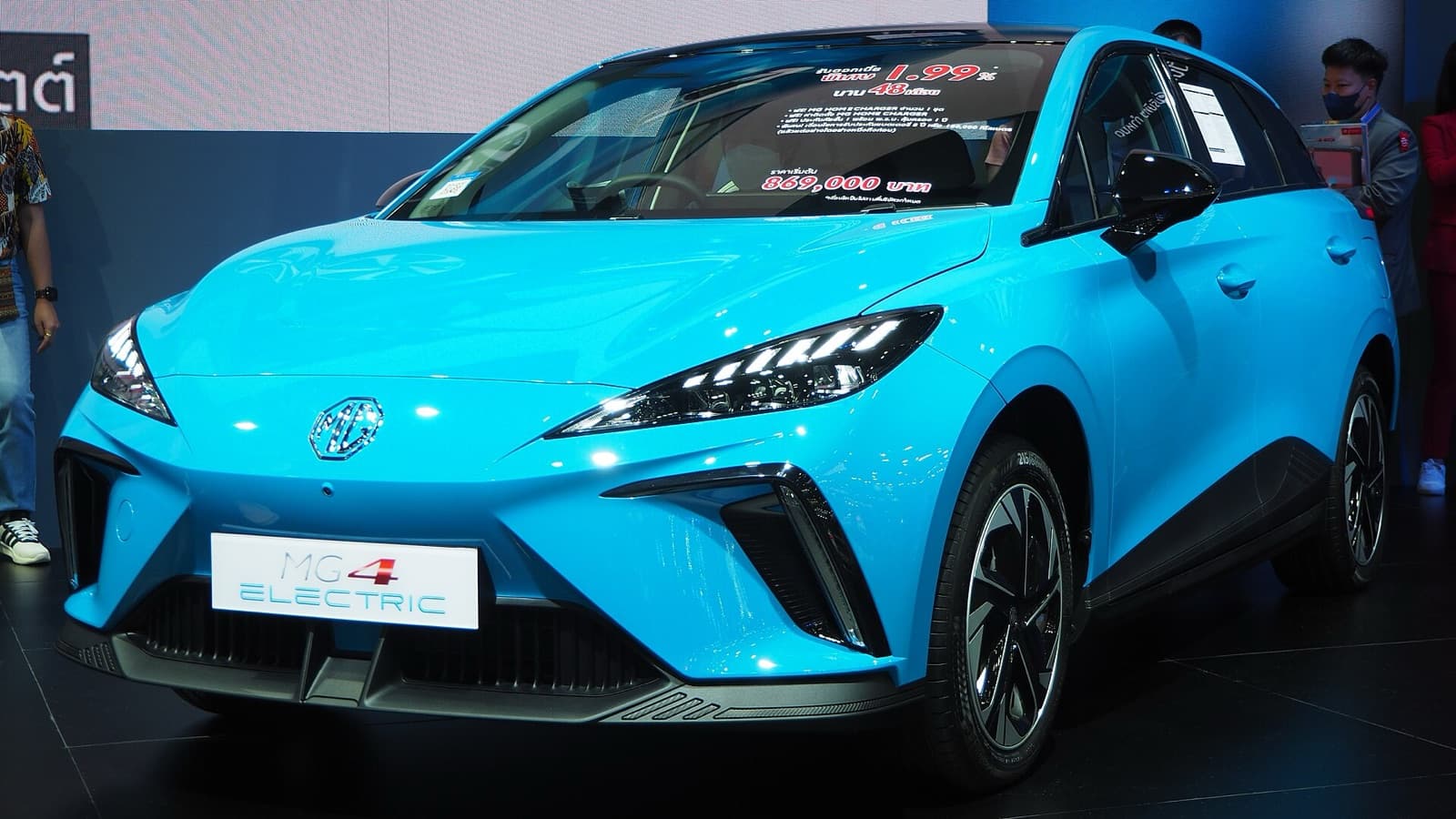 A light blue MG 4 Electric hatchback on display at a motor show, front three-quarter view