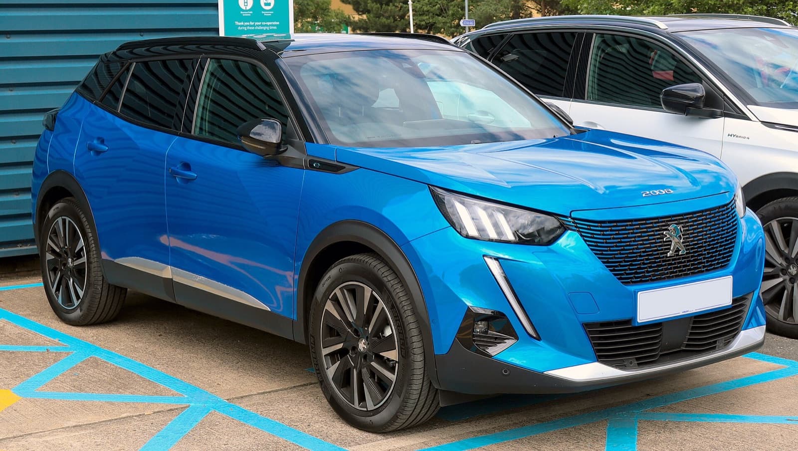 A blue Peugeot e-2008 electric small SUV parked outdoors