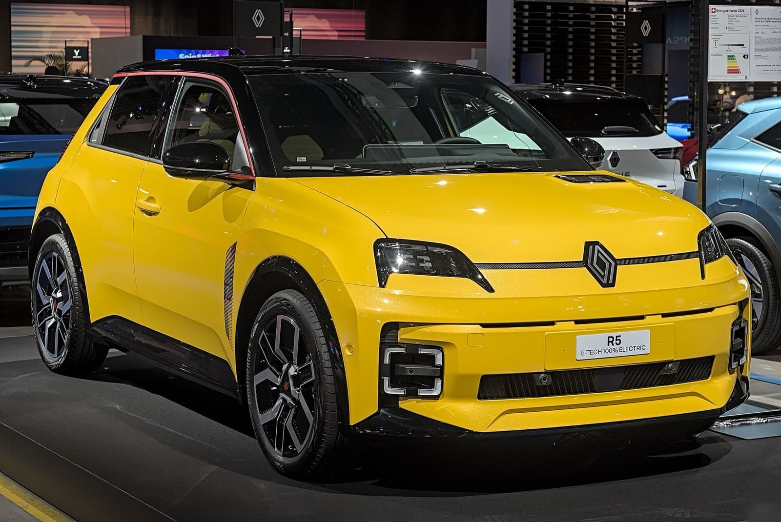A yellow Renault 5 E-Tech Electric supermini at a motor show